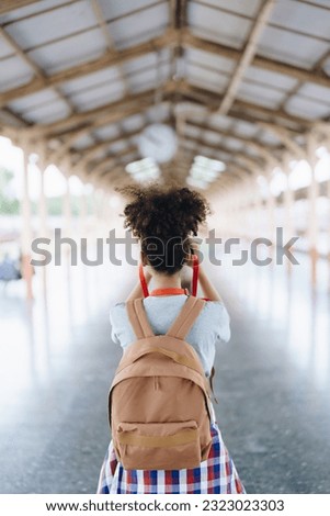 Asian teenage girl african american traveling using a camera take a photo to capture memories while waiting for a train at the station