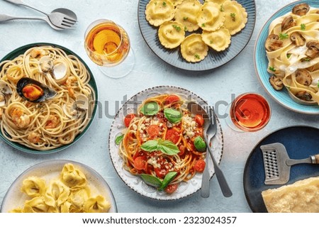 Pasta variety. Italian food and drinks, overhead flat lay shot. Spaghetti marinara, mushroom pappardelle, seafood pasta, wine, Parmesan cheese Royalty-Free Stock Photo #2323024357