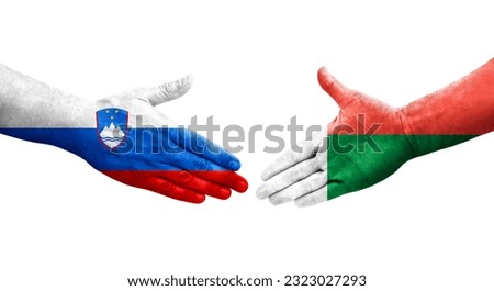 Handshake between Madagascar and Slovenia flags painted on hands, isolated transparent image.