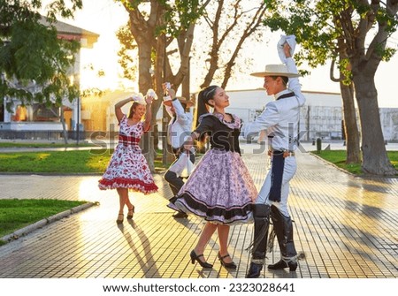 group of two Latin American couples of huaso dancing cueca in the town square at sunset in La Serena Royalty-Free Stock Photo #2323028641