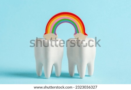 Two teeth with rainbow on blue background. Advertising poster for  dental clinic in the month of pride. Royalty-Free Stock Photo #2323036327