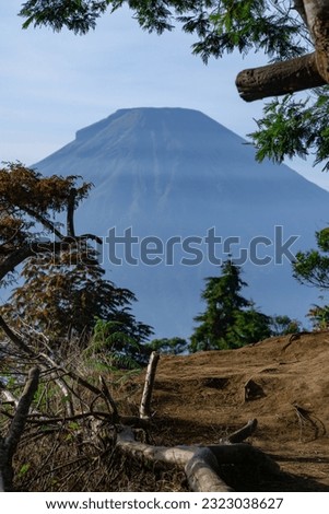 Landscape photo of mountain with trees and blue sky. Sikunir peak, Dieng, Wonosobo