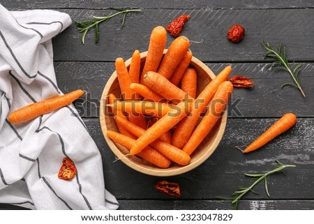 Bowl with fresh carrots and tomatoes on black wooden background Royalty-Free Stock Photo #2323047829