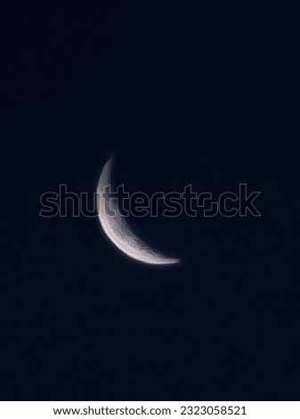 A picture of the crescent moon floating in the night sky. A close-up picture of the moon's surface. a picture of the moon