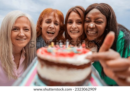 group mature female friends celebrating birthday with cake Royalty-Free Stock Photo #2323062909