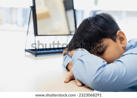 Child boy falls asleep at table classroom. kid pupil education lesson study elementary at desk. Little boy tired sleep after studying.