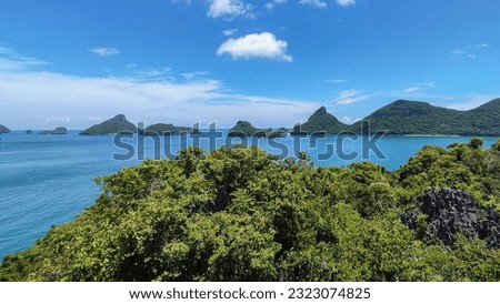 view of beautiful nature lake in the Gulf of Thailand. There is a tot of tree in the foreground. and there is a large and small island in the middle of the picture with the sky in the background