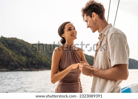 Caucasian young man make surprise proposal of marriage to girlfriend. Attractive romantic male proposing to beautiful happy woman with wedding ring enjoying surprise engagement while yachting together Royalty-Free Stock Photo #2323089391