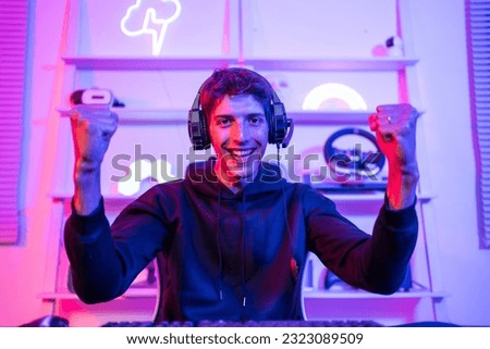 Portrait of Caucasian e-sport male gamer play video game on computer. Handsome man gaming player feel happy and excited, enjoy technology broadcast live streaming while plays cyber tournament at home
