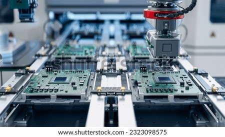 Component Installation on Circuit Board. Fully Automated Modern PCB Assembly Line Equipped with Advanced High Precision Robot Arms at Bright Electronics Factory. Electronic Devices Production Industry Royalty-Free Stock Photo #2323098575