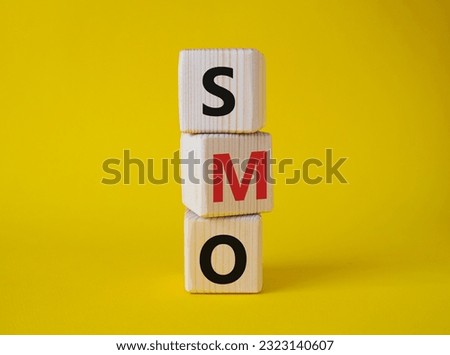 SMO - Social Media Optimization symbol. Wooden blocks with words SMO. Beautiful yellow background. Business and SMO concept. Copy space.