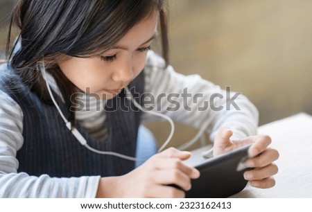 A girl is using a smartphone, learning for new generations of children.