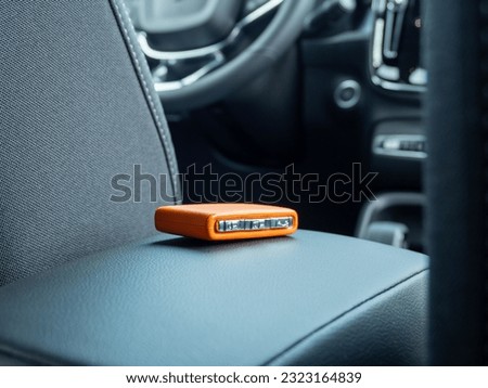 Car ignition key on the armrest in the interior of a modern car. Forgot my keys in the car. Royalty-Free Stock Photo #2323164839