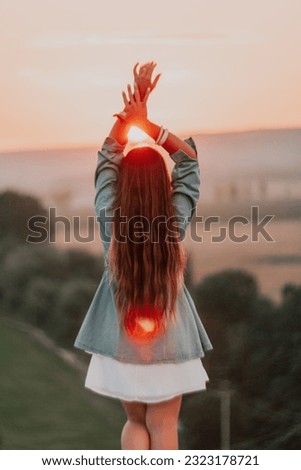 Happy woman standing with her back on the sunset in nature in summer with open hands. Romantic beautiful bride in white boho dress posing with mountains on sunset
