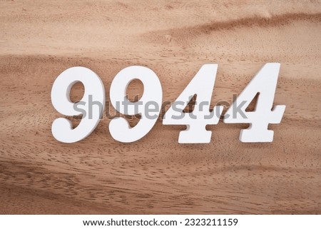 White number 9944 on a brown and light brown wooden background.
