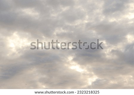 View of the blue sky in the morning with white black clouds and the bright sun shining brightly
