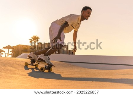 Surf skater training surfing moves near the beach at sunset. Royalty-Free Stock Photo #2323226837