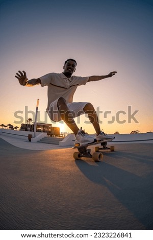 Surf skater training surfing moves near the beach at sunset. Royalty-Free Stock Photo #2323226841