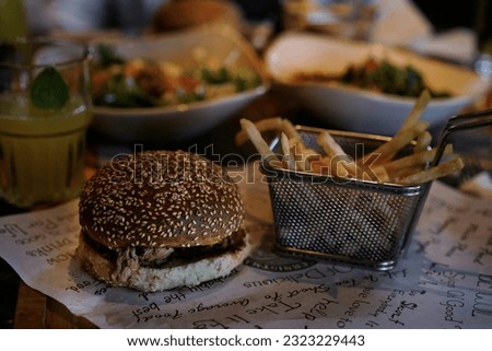 Delicious burgers and french fries on table