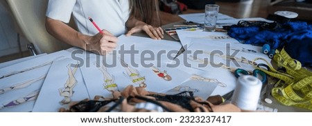 Faceless woman draws sketches of swimwear with a pencil. Close-up of the hands of a fashion designer.