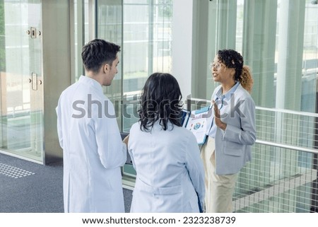 A multinational group having a conversation in the lobby.
People in white coats and sales staff. High angle view. Royalty-Free Stock Photo #2323238739