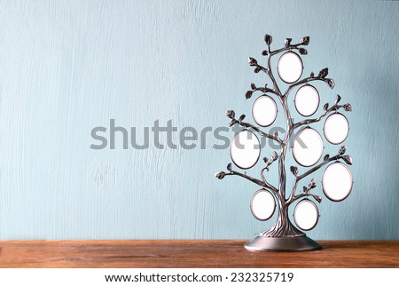Image of vintage antique classical frame of family tree on wooden table 
