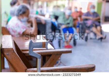 Elderly sitting in a wheelchair with walking stick at Elderly care facility to wait for visitors. Long-term care facility for elder concept. Royalty-Free Stock Photo #2323273349