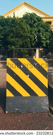 yellow and black barriers are road markings to provide order on the road so there are no traffic jams