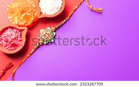 Raksha Bandhan, Indian festival with beautiful Rakhi and Rice Grains.  A traditional Indian wrist band which is a symbol of love between Sisters and Brothers.