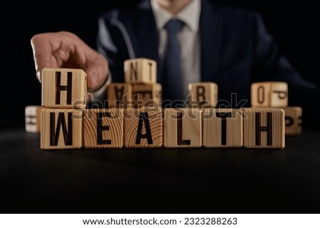 Hand flip wooden cube with word wealth to health.
