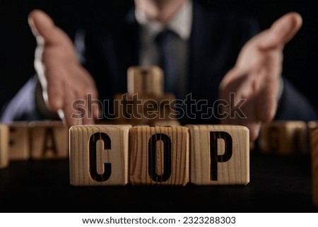 businessman collected the word COP from wooden cubes on a black background