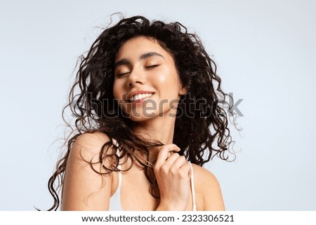 Happy young woman with natural beauty, and beautiful curly hair closed her eyes with pleasure Royalty-Free Stock Photo #2323306521