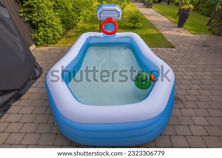 Close-up view of inflatable outdoor swimming pool filled with water in front yard. Sweden.