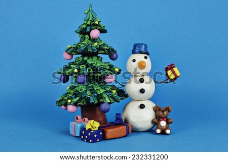 Clay snowman with gifts near Cristmas tree