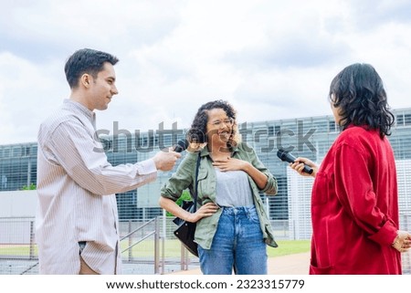 African woman being interviewed on the street by the media. Royalty-Free Stock Photo #2323315779