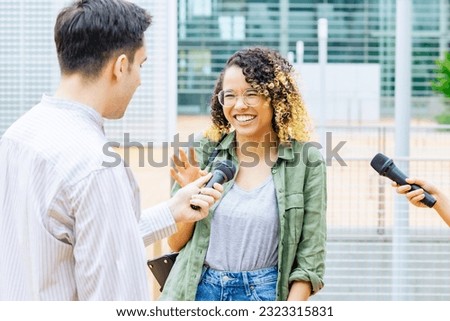 African woman being interviewed on the street by the media. Royalty-Free Stock Photo #2323315831