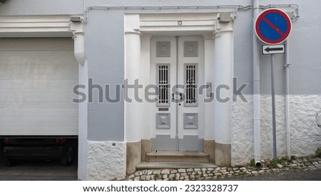 Wooden white gray door entrance to the house with bars on the windows