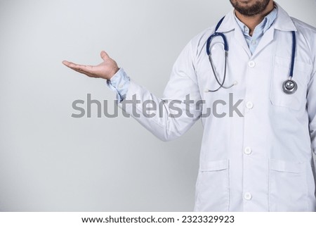 Doctor holding something on grey background. Health care and medical concept.