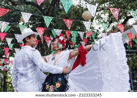 Latin couple of dancers wearing traditional Mexican dress from Veracruz Mexico Latin America, young hispanic woman and man in independence day or cinco de mayo parade or cultural Festival Royalty-Free Stock Photo #2323333245