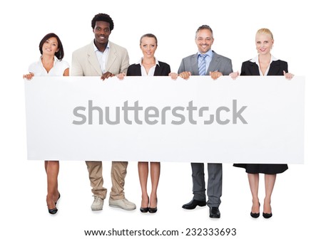 Full length portrait of multiethnic business people holding large billboard over white background