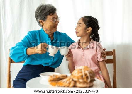Portrait of happy love asian grandmother and asian little cute girl play and enjoy relax on bed at home.senior, insurance, care.Young girl with their laughing grandparents smiling together.Family