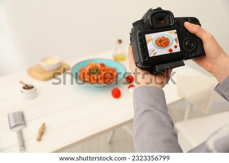 Food stylist taking photo of delicious spaghetti in studio, closeup. Space for text