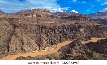 Panoramic aerial view of Colorado River weaving through valleys and rugged terrain seen from Plateau Point, Bright Angel Trail, South Rim, Grand Canyon National Park, Arizona, USA. Brown dirty water Royalty-Free Stock Photo #2323363983