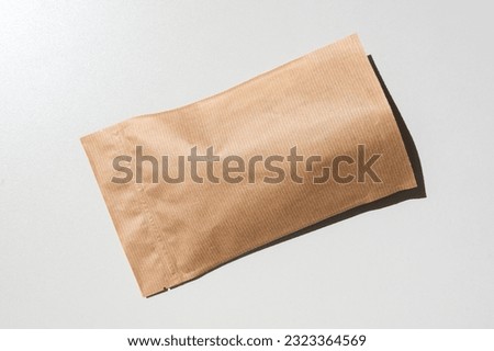 Brown kraft paper pouch bags with coffee beans top view with shadow isolated on white background. Packaging for foods and goods template mockup. Pack with clasp for tea leaves,weight products flat lay Royalty-Free Stock Photo #2323364569