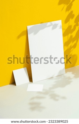 White textured paper  mockup set. A4 paper, sqauer shape paper and business card on yellow background with floral shadows.