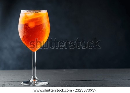 Aperol Spritz cocktail in glass with fresh orange on dark wooden boards. Glass of Aperol Spritz cocktail served in a wine glass. Copy space Royalty-Free Stock Photo #2323390939
