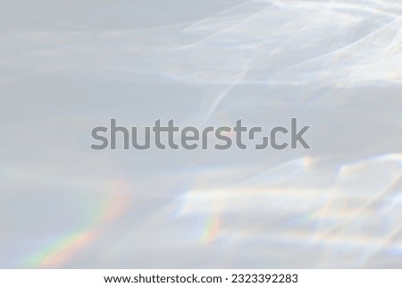 Blurred dreamy surreal rainbow light refraction texture overlay effect for photo and mockups. Organic drop diagonal holographic flare on a white wall. Water shadows for natural light effects Royalty-Free Stock Photo #2323392283