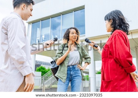 African woman being interviewed on the street by the media. Royalty-Free Stock Photo #2323397035