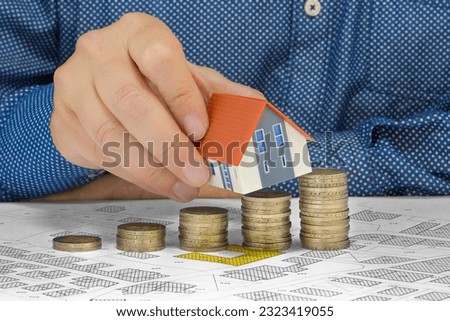 Property Tax on buildings - Property Real Estate concept with a small home model, euro coins group and imaginary cadastral map - Growth in property value Royalty-Free Stock Photo #2323419055