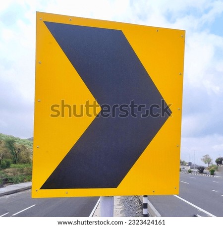 A black and yellow chevron sign warning about dangerous curves, medians, bridges and obstacles